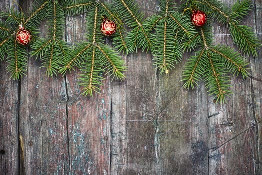 Retro wooden background with fir tree branches and Christmas decorations.Copy space