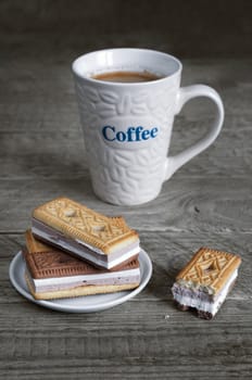 Cookies and coffee on wooden surface. Morning, selective focus. Mug with inscription.