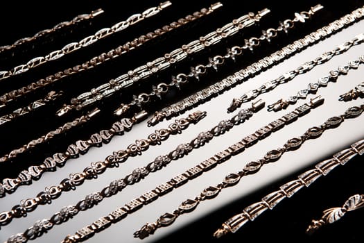 Golden bracelets on a black glass background with white highlight