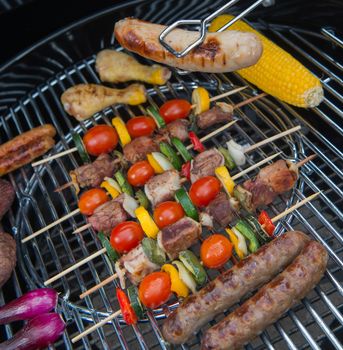 Assorted delicious grilled meat with vegetable over the coals on a barbecue