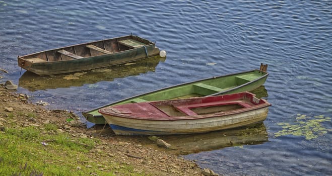 Three old boats on the river and grass