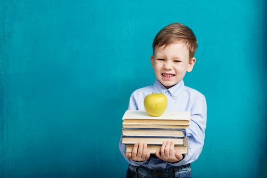 Book, school, kid. little student holding books. Cheerful smiling little kid against chalkboard. Looking at camera. School concept. Back to School