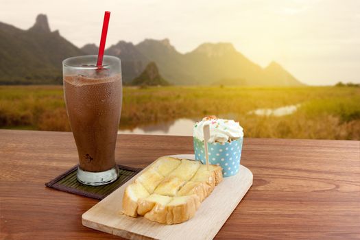 Cocoa chocolate smoothie in glass and Buttered bread and cup cake