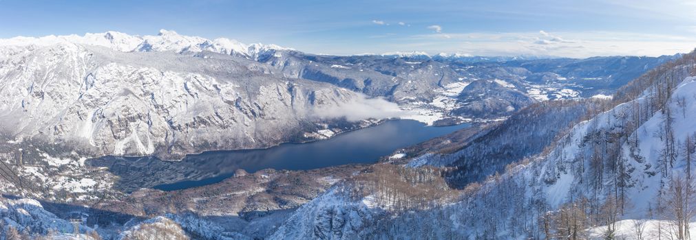 A view of the Lake Bohinj and the surrounding mountains in winter.