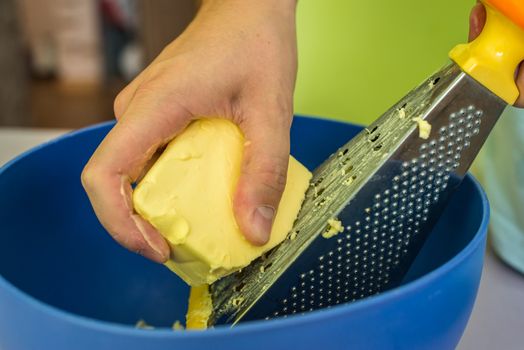 hand shredded cold butter with grated in a blue bowl