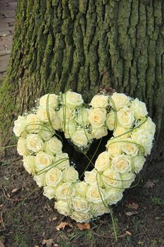 Heart shaped sympathy flowers near a tree