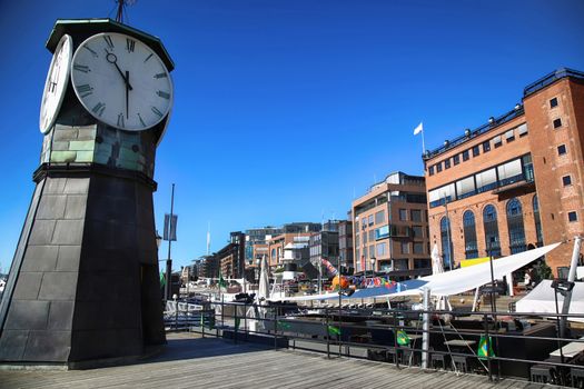 Clock tower on Aker Brygge Dock and modern building in Oslo, Norway