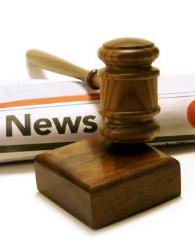 Newspaper and gavel for many legal issues in the current trends.