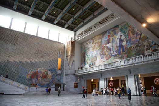 OSLO, NORWAY – AUGUST 18, 2016: Tourists visit in interior of the Oslo City Hall in Oslo, Norway on August 18,2016.