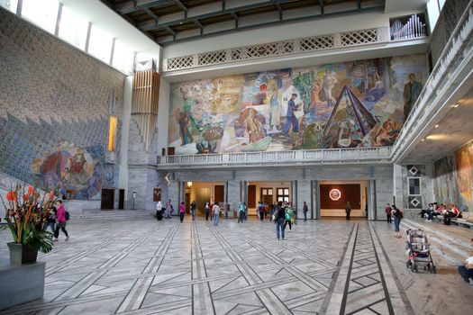 OSLO, NORWAY – AUGUST 18, 2016: Tourists visit in interior of the Oslo City Hall in Oslo, Norway on August 18,2016.