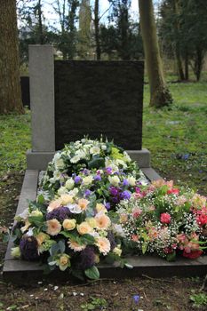 Multicolored sympathy flowers on an old grave