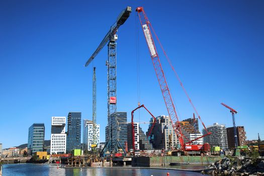 OSLO, NORWAY – AUGUST 17, 2016: A construction site of Bjorvika under construction in progress with a heavy vehicle and cranes in Oslo, Norway on August 17,2016.