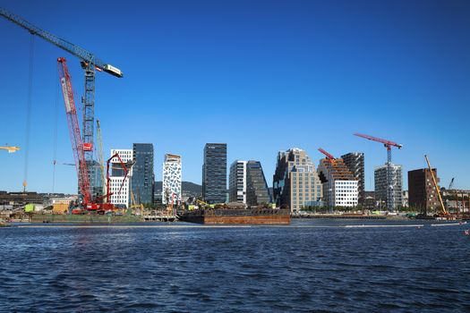 OSLO, NORWAY – AUGUST 17, 2016: A construction site of Bjorvika under construction in progress with a heavy vehicle and cranes in Oslo, Norway on August 17,2016.