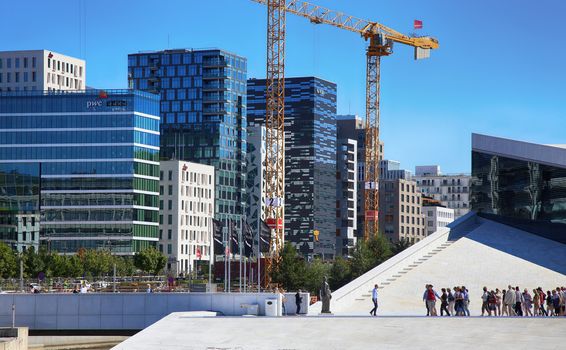 OSLO, NORWAY – AUGUST 17, 2016: Tourist on the Oslo Opera House which is home of Norwegian National Opera and Ballet and National Opera Theatre in Oslo, Norway on August 17,2016.