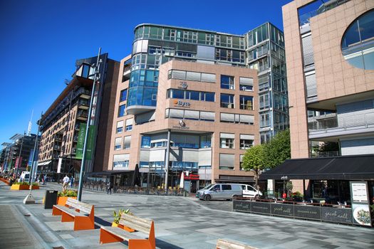 OSLO, NORWAY – AUGUST 17, 2016: People walking on modern district on street Stranden, Aker Brygge district with lux apartments, shopping, culture and restaurants in Oslo, Norway on August 17,2016.