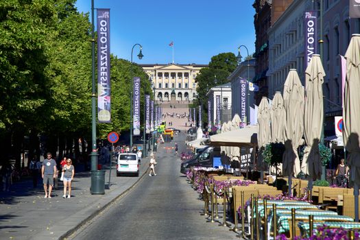OSLO, NORWAY - AUGUST 18, 2016: People walk Oslo's main street Karl Johans at center with the Royal Palace in the background in Oslo, Norway on August 18, 2016. 