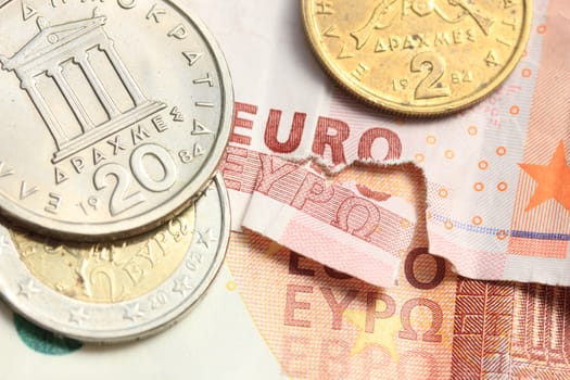 Euro crisis, a vintage Greek Drachma coin and a torn euro note