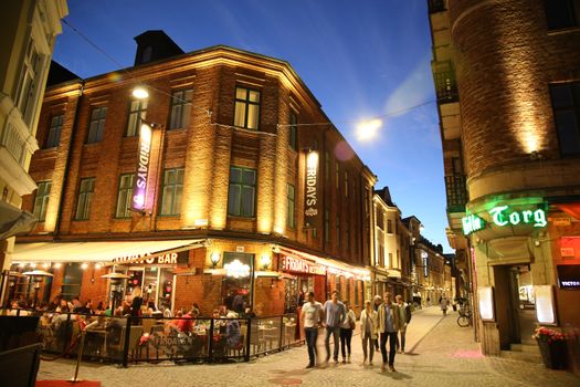 MALMO, SWEDEN - AUGUST 16, 2016: People walk on crossroad of the streets Master Johansgatan, Lilla Torg and Landbygatan street in old part of Malmo, street life in Malmo, Sweden on August 16, 2016.