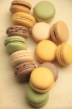 Macarons in different colors and flavors on a wooden cutboard