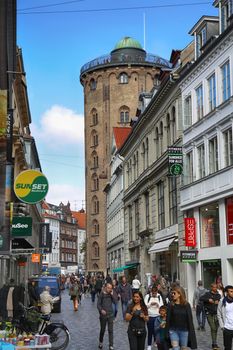 COPENHAGEN, DENMARK - AUGUST  15, 2016: Many pedestrians in Kobmagergade street, view on Rundetaarn built by king Christian the fourth in the years 1637-42 in Copenhagen, Denmark on August 15, 2016.