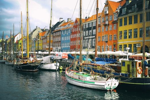 COPENHAGEN, DENMARK - AUGUST 15, 2016: Boats in the docks Nyhavn, people, restaurants and colorful architecture. Nyhavn a 17th century harbour in Copenhagen, Denmark on August 15, 2016.