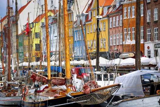 COPENHAGEN, DENMARK - AUGUST 15, 2016: Boats in the docks Nyhavn, people, restaurants and colorful architecture. Nyhavn a 17th century harbour in Copenhagen, Denmark on August 15, 2016.