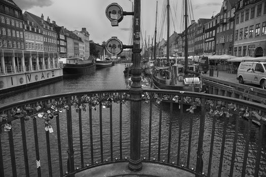 COPENHAGEN, DENMARK - AUGUST 15, 2016: Black and white photo, boats in the docks Nyhavn, people, and colorful architecture. Nyhavn a 17th century harbour in Copenhagen, Denmark on August 15, 2016.