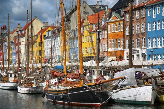 COPENHAGEN, DENMARK - AUGUST 14, 2016: Boats in the docks Nyhavn, people, restaurants and colorful architecture. Nyhavn a 17th century harbour in Copenhagen, Denmark on August 14, 2016.