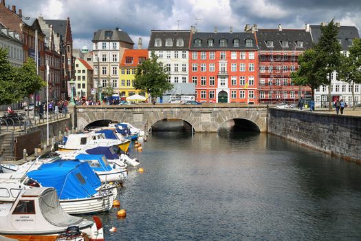 COPENHAGEN, DENMARK - AUGUST 14, 2016: View of canal, boat with tourist and old bridge from bridge Marmorbroen in Copenhagen, Denmark on August 14, 2016.