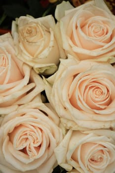 Pale pink roses in a floral arrangement at a wedding