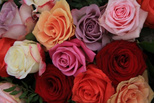 Roses in various bright colors in a mixed bridak bouquet