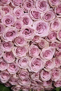 Purple roses in a big floral wedding arrangement