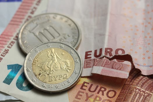 Euro crisis, a vintage Greek Drachma coin and a torn euro note