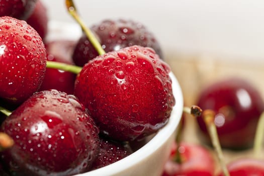 photographed close-up of ripe red cherries covered with water drops, shallow depth of field