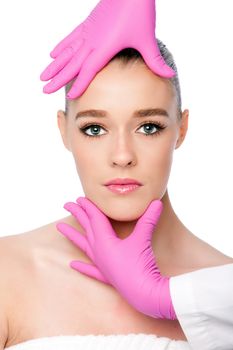 Beautiful face ready for Cosmetic skincare spa beauty treatment with pink gloves, on white.
