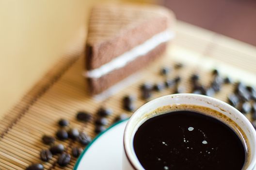 A cup of coffee with slice of chocolate cake on White background