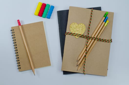 Recycled paper notebook pencils on white background