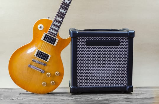 Electric guitar and amplifier isolated on a  light brown