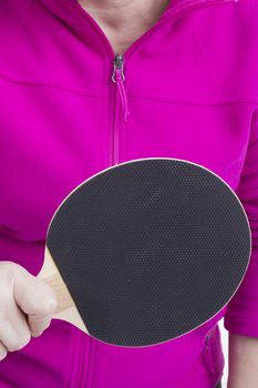 Active senior woman playing table tennis in front of white background