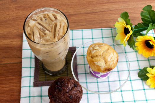 Cocoa chocolate smoothie in glass and muffin on wood table
