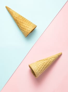 Creative photo of  two empty waffle cones on pink and blue background.