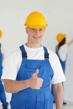 Workman gives thumbs up in front of two painters