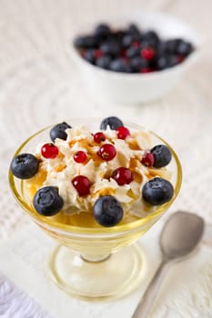 Closeup of a dessert with berries and cream with berries on background