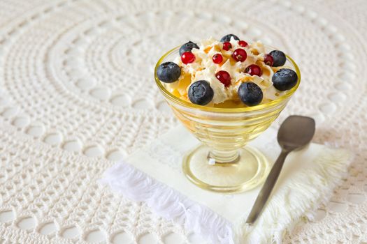 Dessert with berries and cream over a tablecloth