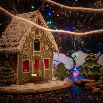 Gingerbread house with lights on dark background, xmas theme