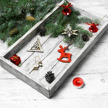 Wooden box with Christmas toys and Christmas tree branch