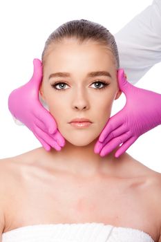 Beautiful face ready for Cosmetic skincare spa beauty treatment with pink gloves, on white.