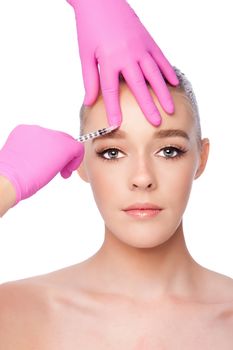 Beautiful face frown wrinkles injection on forehead Cosmetic skincare spa beauty treatment with pink gloves by eye, on white.
