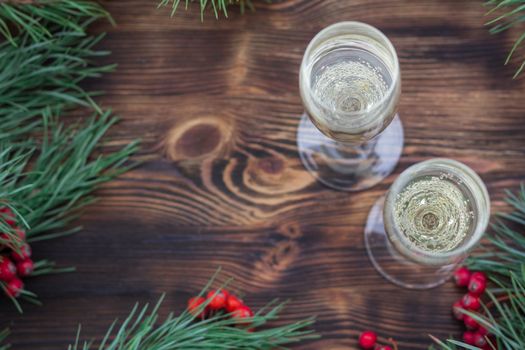 Christmas and New Year seasonal composition with pine tree branches, two glasses of champaign and red rowan berries