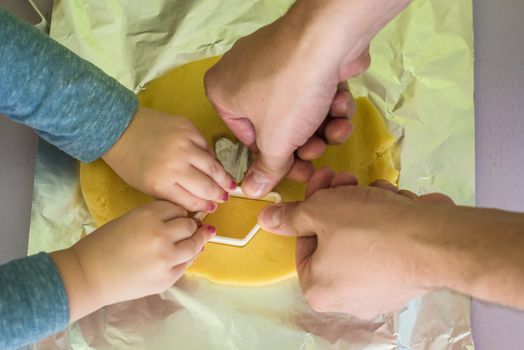 child and dad makes shape of shortcrust dough with cookie cutters